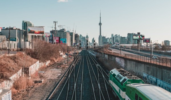 Metrolinx's GO train tracks with GO train in the foreground and CN tower in the background