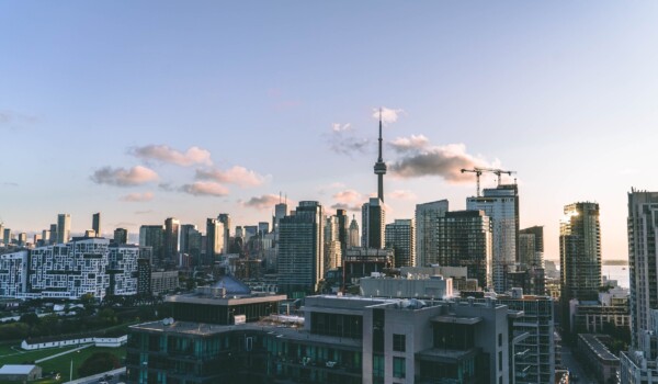 Buildings against a blue sky background with several clouds in the distance.