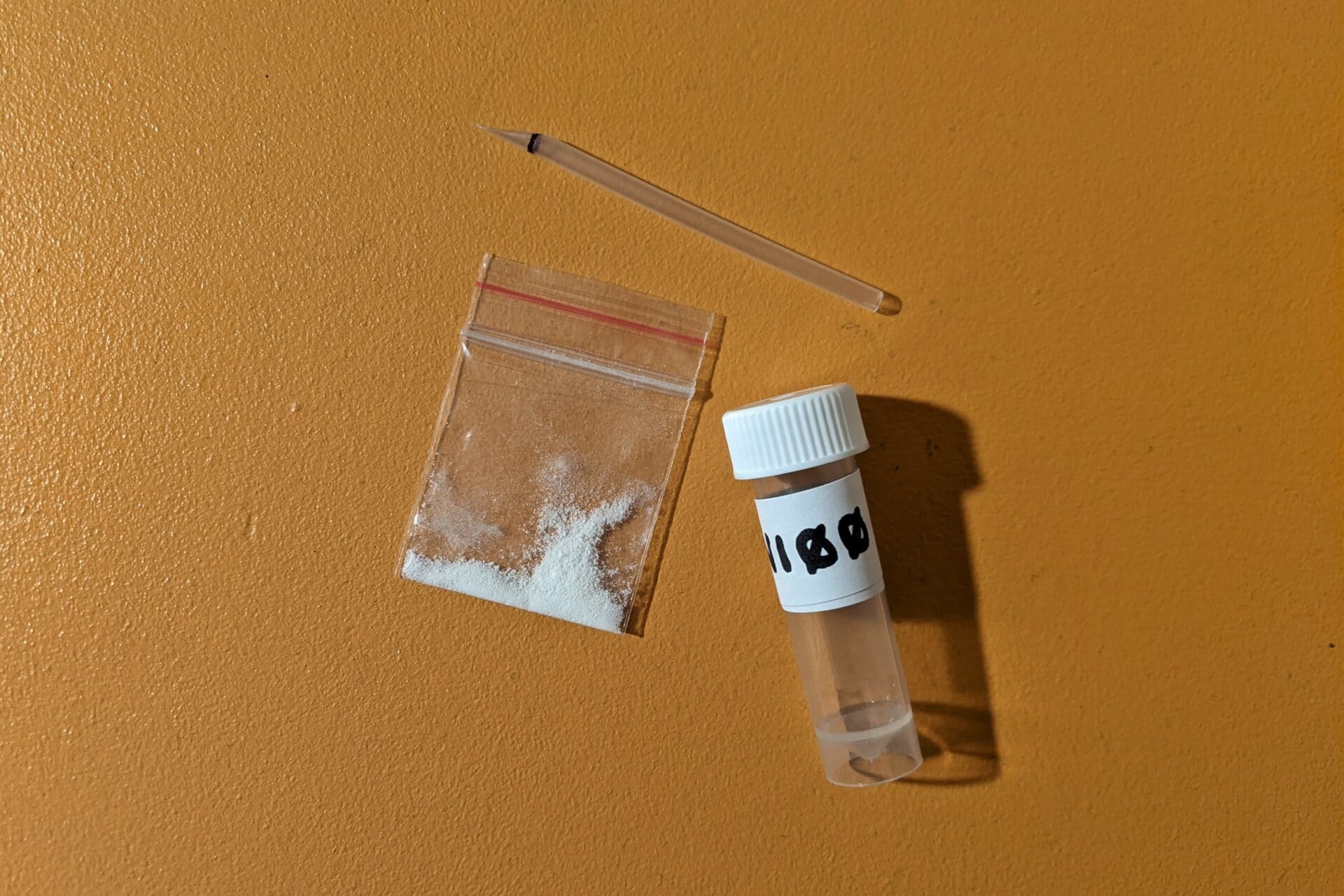 Drug paraphernalia, a small sample of white powder and a sampling container.